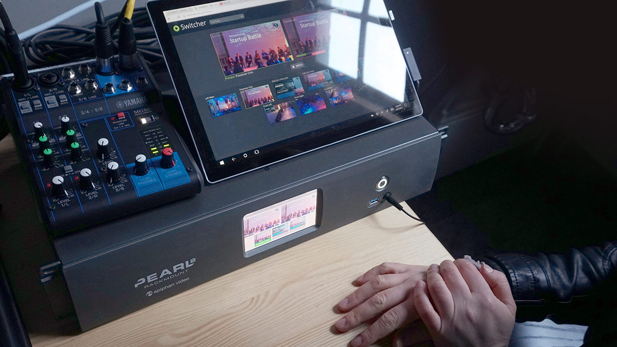 livestream producer running a YouTube latency test with laptop smartphone and encoder notes